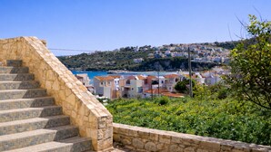 A stone staircase leading to a coastal town with houses and a view of the sea. - Elysian Seaside Villa (Almyrida)