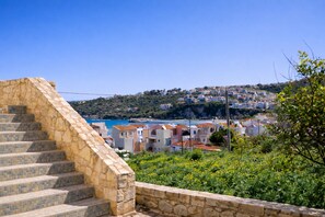 A stone staircase leading to a coastal town with houses and a view of the sea. - Elysian Seaside Villa (Almyrida)