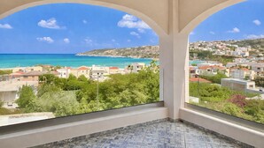 A balcony with a view of a coastal town and the sea. - Elysian Seaside Villa (Almyrida)