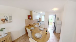 Una cocina compacta con comedor, refrigerador y ventana.