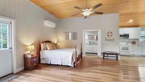 A bedroom with a wooden ceiling fan, a bed with white bedding, a nightstand, and a bedside lamp. - The Low Country Loft- Comfy 1BDRM Loft-4 Pass Golf Cart Included (Daufuskie Island)