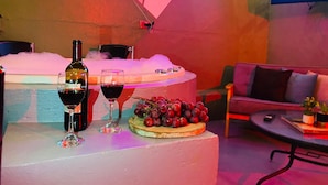 A bar area with a neon sign, a bottle of wine, glasses, and a fruit platter. - Libertador Aptos l Jacuzzi l In Provenza (Medellín)