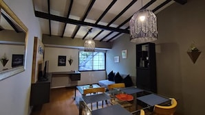 A dining area with a glass table, chairs, and pendant lighting. - Libertador Aptos l Jacuzzi l In Provenza (Medellín)