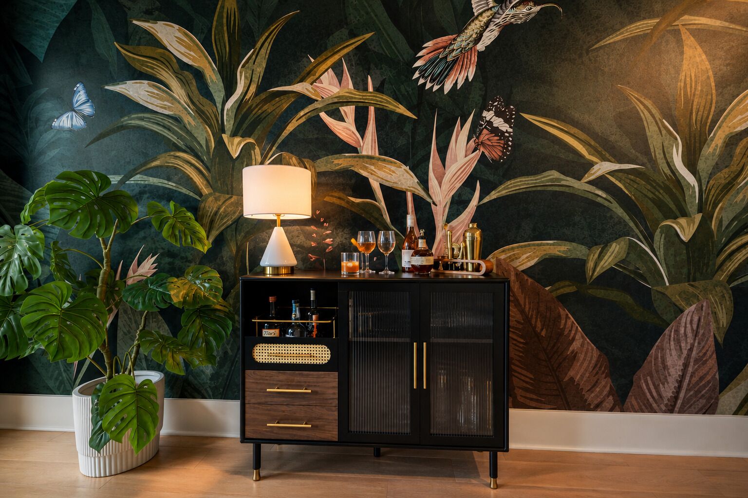 A room with a dark-themed mural, a black cabinet with drawers, a table lamp, and a potted plant.