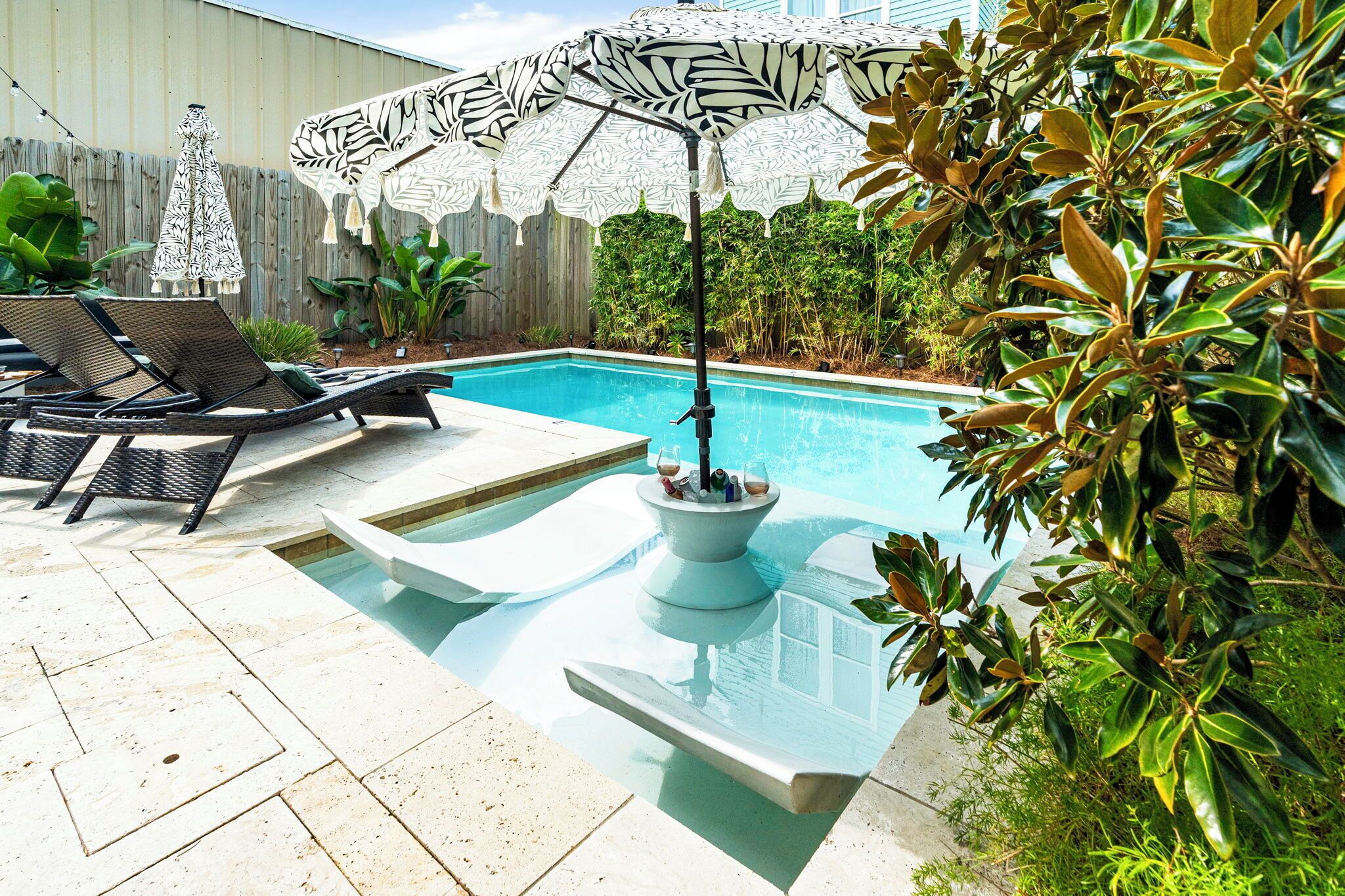 A swimming pool with lounge chairs and a decorative umbrella.