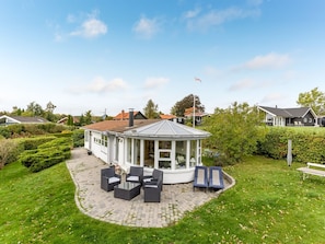 A house with a conservatory, outdoor seating, and a well-maintained garden. - "Söhnke" - 100m to the fjord by Interhome (Faxe)