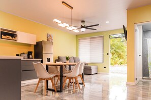 Eine moderne Küche mit Essbereich, Deckenventilator und einem Fenster mit Jalousien.
