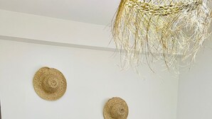 Une chambre à coucher avec un lit, un luminaire suspendu et deux chapeaux accrochés au mur.