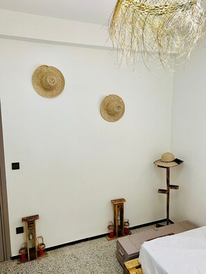 A bedroom with a bed, a hanging light fixture, and two wall-mounted hats. - Aji darna -cozy morrocan stay in fes (Fes)