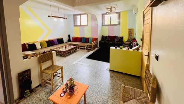 Un salon comprenant un canapé, une table basse, un fauteuil et une petite table sur laquelle est posé un vase.