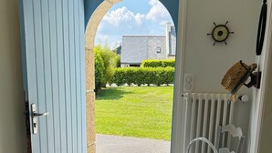 A blue door leading to a tiled entrance area with a white chair and a basket. - Les Lutins - Family home - Private beach access (Concarneau)