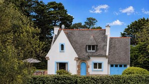 A two-story house with a sloped roof, a satellite dish, and a chimney. - Les Lutins - Family home - Private beach access (Concarneau)
