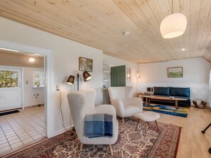 A spacious living room with a high ceiling, a sofa set, a coffee table, and a patterned rug. - "Petteri" - 600m to the fjord by Interhome (Tim)