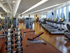 A modern gym with various exercise equipment, including treadmills, weight machines, and free weights. - Premium 1BR living |Comfort & Class + City Center (Dubai)