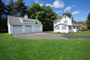 A two-story house with a garage, a driveway, and a well-maintained lawn. - New Stylish 2BR Garage Balcony Pet Friendly Fast WiFi (Farmington)