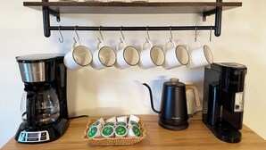 A coffee station with two coffee makers, a basket of coffee pods, and a rack of mugs. - Farmington gem near UConn Health with garage • Fast Wi-Fi • Dog Friendly (Farmington)