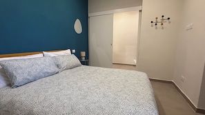 A bedroom with a bed, a nightstand, a lamp, and a wall-mounted light fixture. - Lucky Villa-your apartment in Naples near the Reggia di Capodimonte (Napoli)