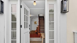 A hallway with a wooden staircase, a bench, and a guitar leaning against the wall. - Charming & Peaceful Catskills Getaway 2hr from NYC (Mountain Dale)