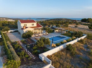 Ein Haus mit Swimmingpool, Sitzgelegenheit im Freien und Meerblick.