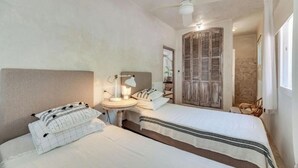 A bedroom with two beds, a bedside table, a lamp, and a wardrobe. - Magnificent 3-bedroom Andalusian family villa near the beach and Puerto Banús (Marbella)