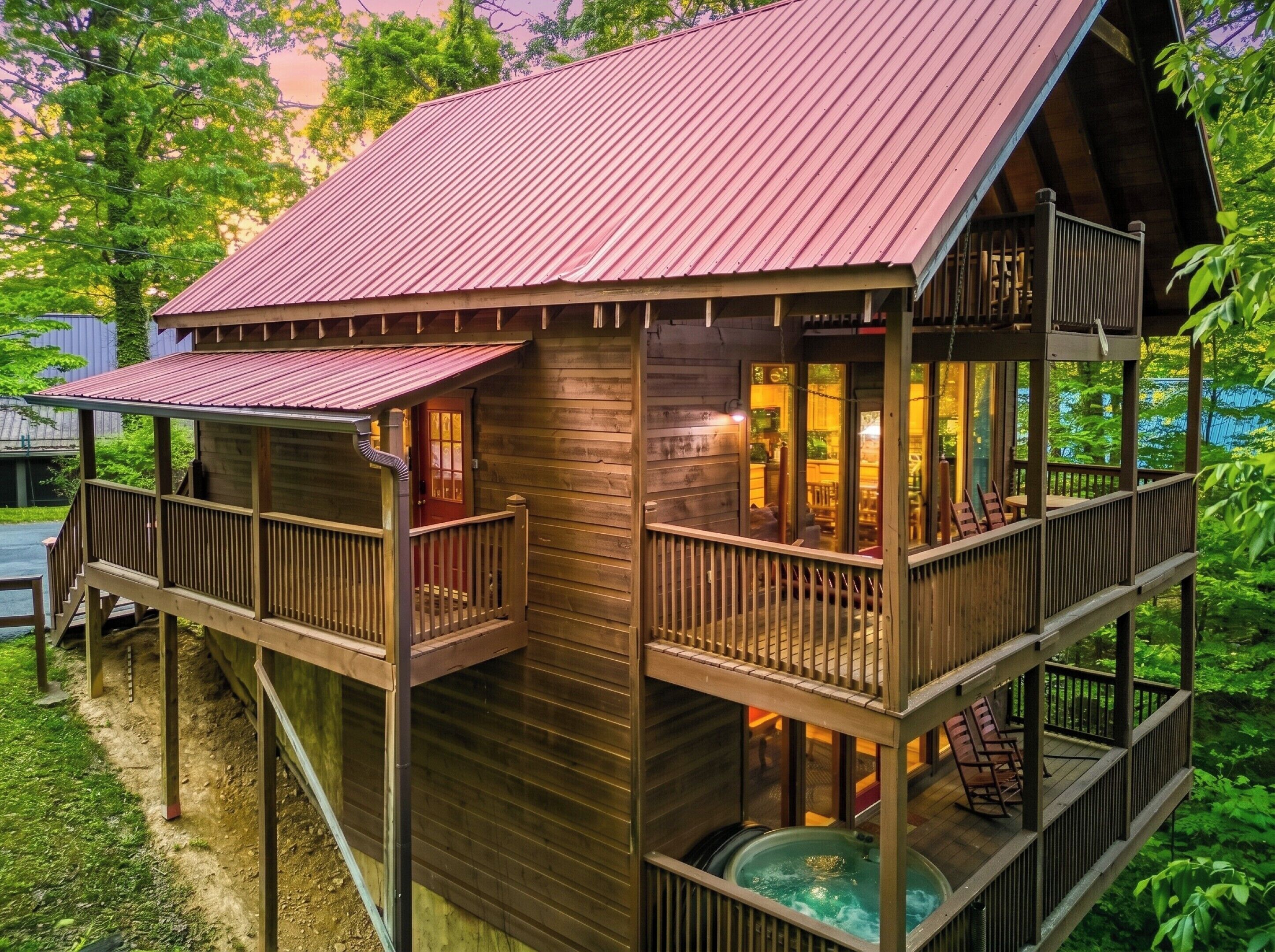 Een houten blokhut met een rood dak, een jacuzzi en een balkon.