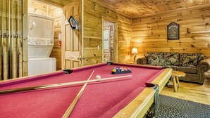 A wooden interior with a pool table, a sofa, and a fireplace. - Mountain Views & Hot Tub | Near Dollywood (Sevierville)