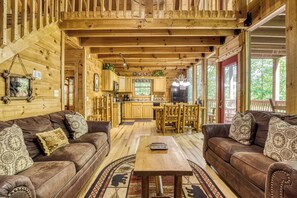 A wooden cabin interior with a living room, kitchen, and dining area. - Bear-rif-ic Cabin w/ Hot Tub & Pool Table (Sevierville)