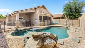 Ein Wohnhaus mit Swimmingpool, überdachter Terrasse und umzäunter Garten.