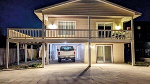 Una casa a due piani con garage, un portico coperto e un balcone.