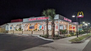 Un ristorante chiamato 'Island Burgers' con un cartello McDonald's nelle vicinanze.