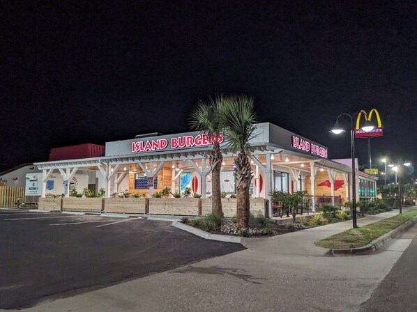 Un restaurante llamado 'Island Burgers' con un letrero de McDonald's cerca.