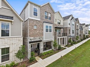 A row of townhouses with brick and siding exteriors, a front porch, and a sidewalk. - Spacious 3-bedroom house with office in beautiful Dallas for the World Cup (Dallas)