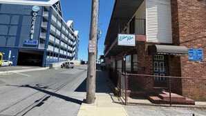 Un edificio de varios pisos con un letrero que dice 'Eden Roc Downtown Efficiencies' y un letrero de 'No Estacionar o Detenerse' en un poste de servicios.
