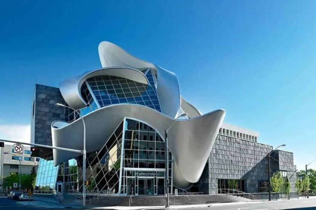 A modern building with a unique curved design, large windows, and a prominent entrance.