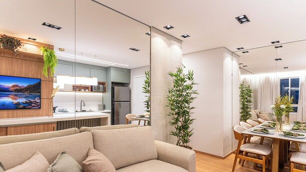 A modern living room with a sofa, dining table, and kitchen area.
