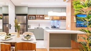A modern kitchen with a central island, built-in appliances, and a dining area with a table set for two.
