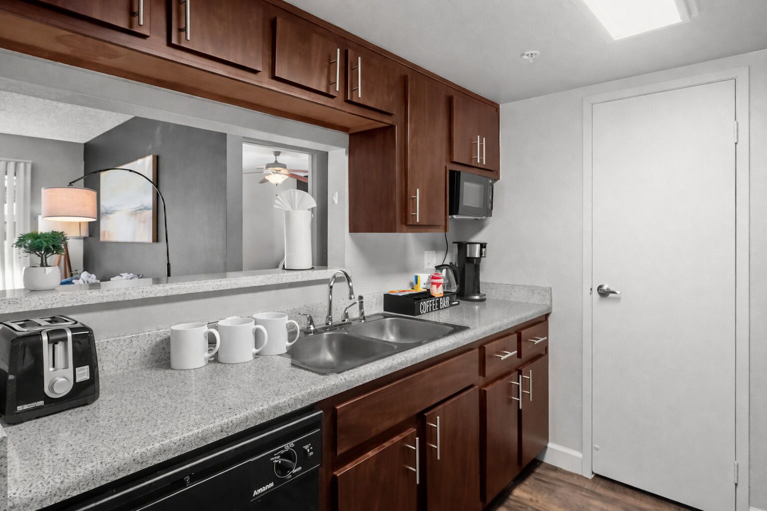 A kitchen with a dishwasher, coffee maker, and toaster.