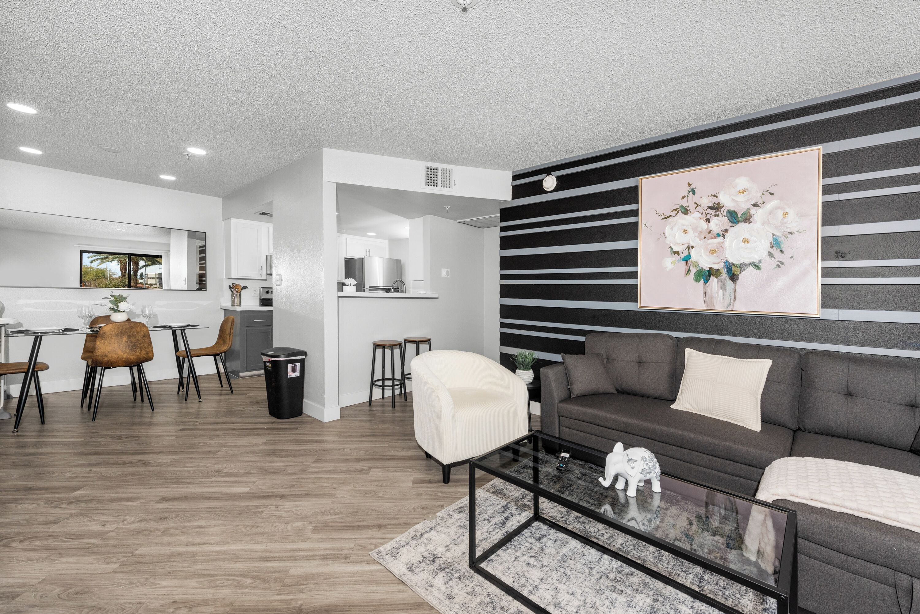 Una sala de estar moderna con sofá, mesa de centro y comedor.