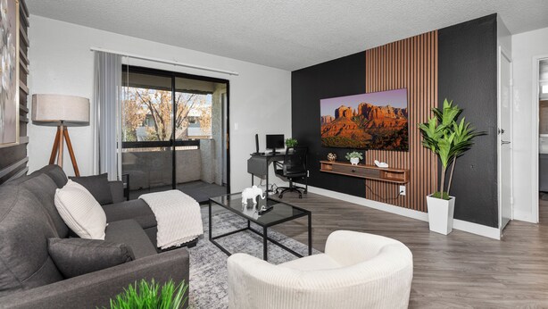 A modern living room with a sofa, armchair, coffee table, and a large painting on the wall. - The Asteria by Stylish Stays (Tempe)