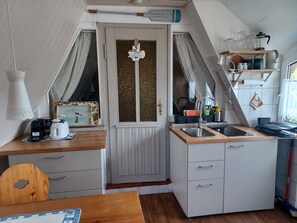 Eine kleine Küchenzeile mit Spüle, Kaffeemaschine und Toaster.