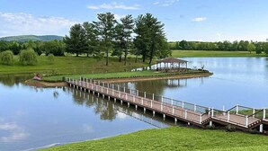 Un entorno tranquilo junto al lago, con un puente de madera que conduce a un pabellón.