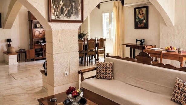 Ein geräumiges Wohnzimmer mit einer Couch, einem Holztisch und einem Essbereich mit Tisch und Stühlen.