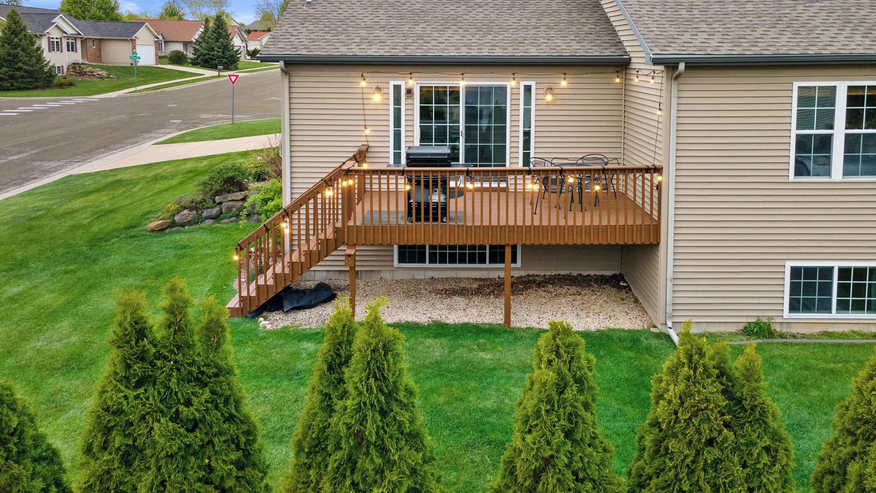 A two-story house with a wooden deck and a garage.