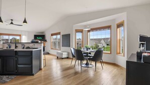 Una cucina moderna con zona pranzo, ampie finestre e vista all'esterno.