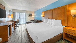 Una habitación de hotel con una cama grande, un escritorio, una silla y un televisor.