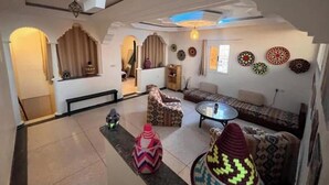 Uma sala de estar espaçosa com um sofá, uma mesa de centro e almofadas decorativas.