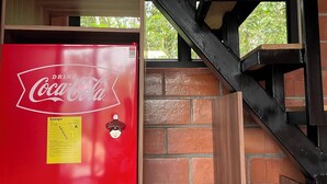 A staircase with a red Coca-Cola refrigerator on the left. - Refugio de la Niebla Puyo Glamping (Puyo)