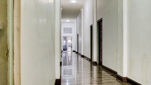 A long, narrow hallway with white walls and a shiny tiled floor, leading to a door at the end. -  Townhouse Oak near Duta Mall Palangka Raya formerly Hotel Nascar Family (Palangkaraya)