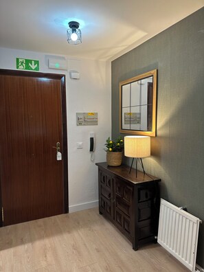 A room with a wooden door, a mirror, a lamp, a plant, a phone, and a light fixture. - Free Parking & WiFi: Your base in Haro (Haro)