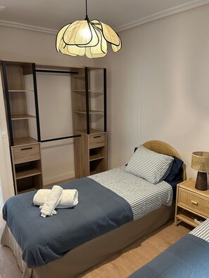A bedroom with a bed, bedside table, lamp, wardrobe, and hanging light fixture. - Free Parking & WiFi: Your base in Haro (Haro)